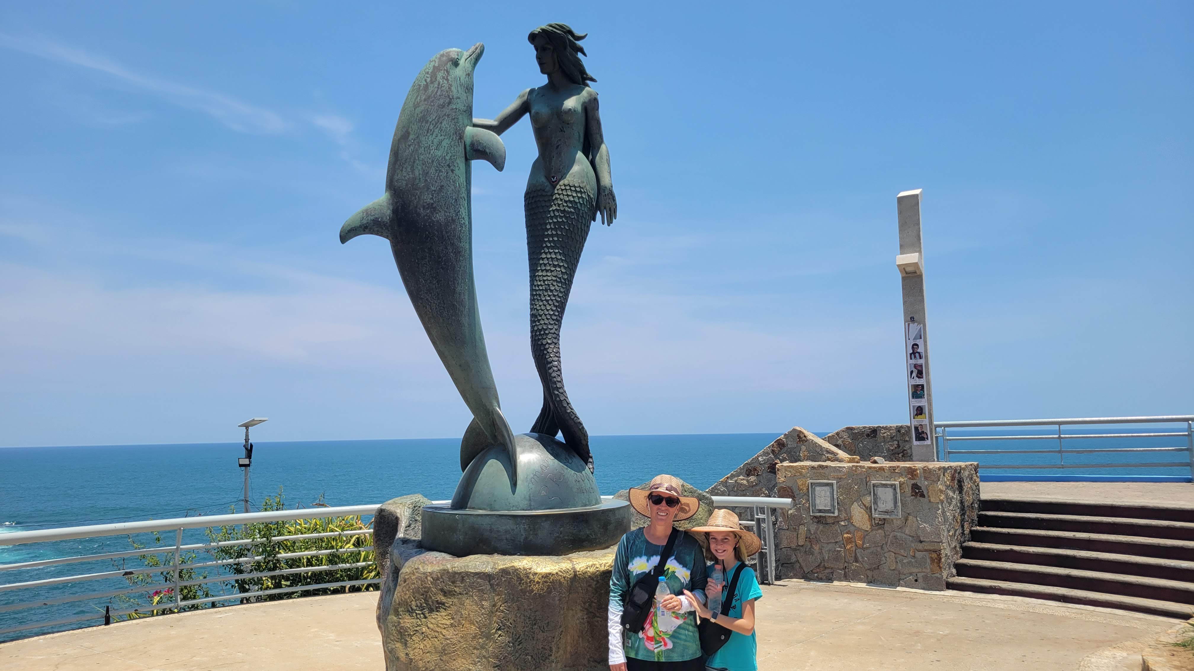 Grete And Fira At Mermaid Statue In Acapulco